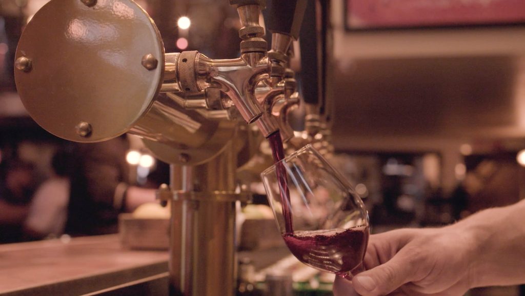 wine pouring out of tap into glass
